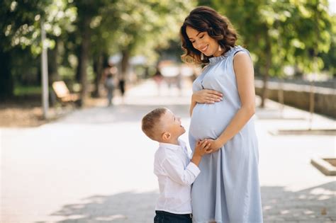 Mujer Embarazada Y Su Pequeño Hijo En El Parque Foto Gratis