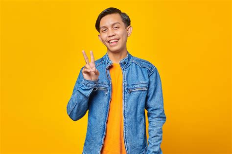 Attractive Smiling Young Asian Man Doing Peace Sign With Hand 3680667