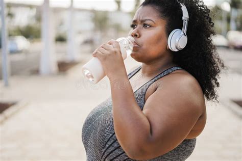 Curvy Black Woman Drinking After Jog Routine Outdoor At City Park Focus On Face Stock Image