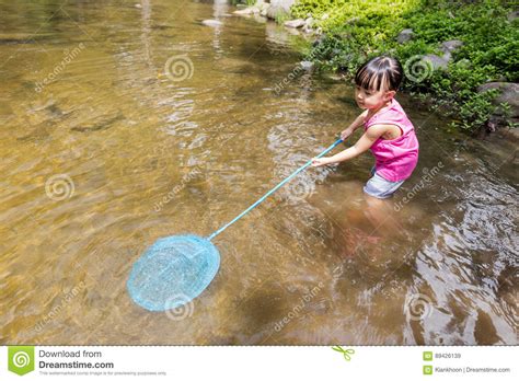 Asian Chinese Little Girl Catching Fish With Fishing Net Stock Image