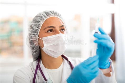 Girl Nurse In Mask Holding Syringe For Injection In Clinic Stock Image