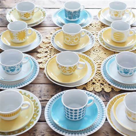 A Table Topped With Lots Of Yellow And Blue Plates Covered In Cups And