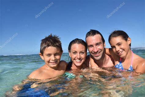 Familia Disfrutando De La Piscina — Foto De Stock © Goodluz 100575164