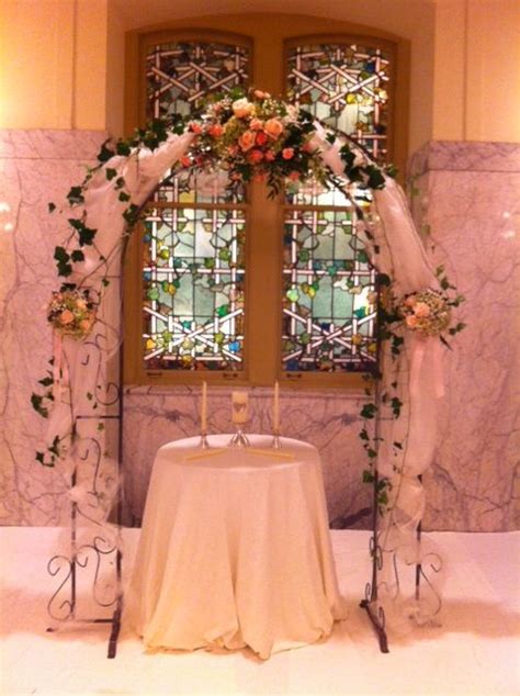 Ceremony Arch Decorated In Fabric And Bridal Flowers