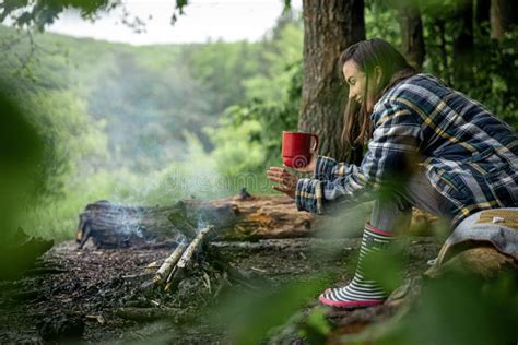 Young Woman Resting Near The Fire With A Cup Of Warming Drink In The Forest Stock Image Image