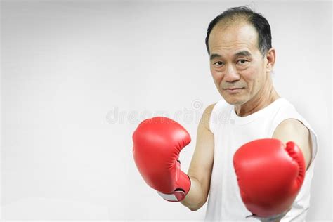 Portrait Of Asian Senior Fighter Man With Red Boxing Gloves Stock Photo