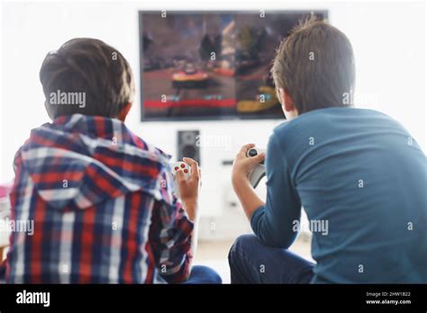 Game Time Rearview Shot Of Two Boys Playing A Video Game In The Living