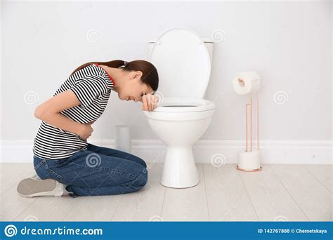Young Woman Suffering From Nausea At Toilet Bowl Indoors Stock Photo