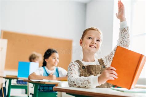 Schoolgirl Raising Hand To Answer Teachers Question Stock Image Image