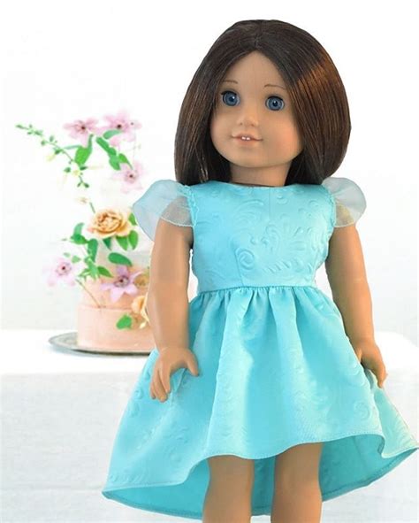 The Doll Is Wearing A Blue Dress And Shoes