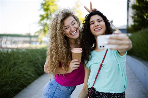 dua pacar bersenangsenang di luar ruangan bersama dan mengambil selfie foto stok unduh gambar