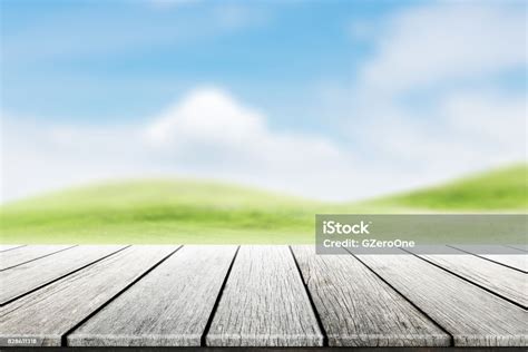 Wood Table Top On Blurred Mound Slope Green Grass Natural Background In