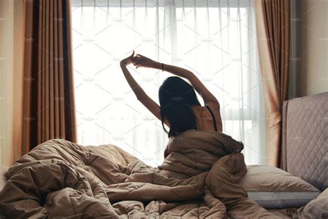 Happy Woman Back View Waking Up Stretching In Bed Room Hotel Bedroom