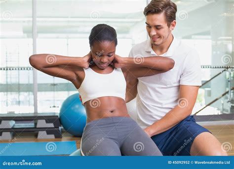 Personal Trainer Working With Client On Exercise Ball Stock Photo