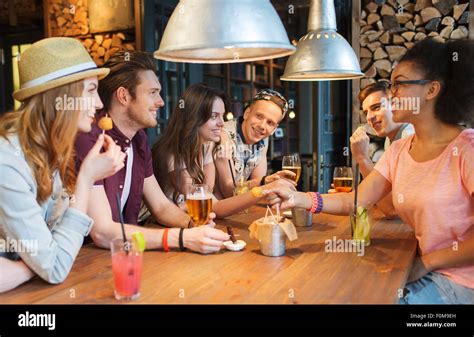 Happy Friends With Drinks Talking At Bar Or Pub Stock Photo Alamy