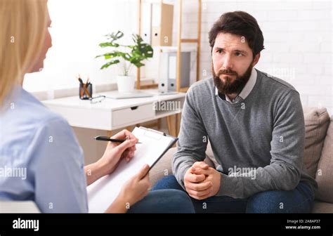 Stressed Young Man Talking To Psychologist At Therapy Stock Photo Alamy
