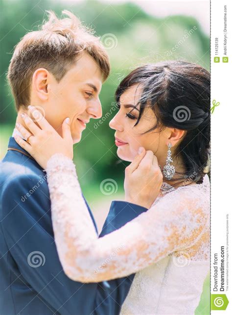 The Newlywed Couple Is Stroking Each Other Cheeks The Close Up Side