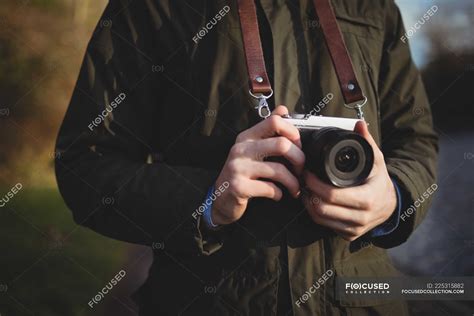 Mid Section Of Man Holding Camera Outdoors — Photographic Male Stock