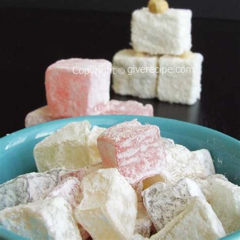Several Different Types Of Marshmallows In A Blue Bowl On A Black Table