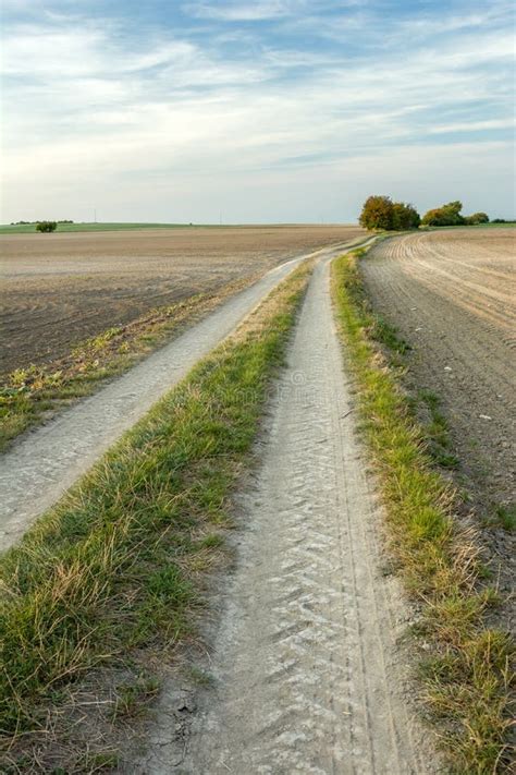 Long Dirt Road Between Plowed Fields Horizon And Sky Stock Image