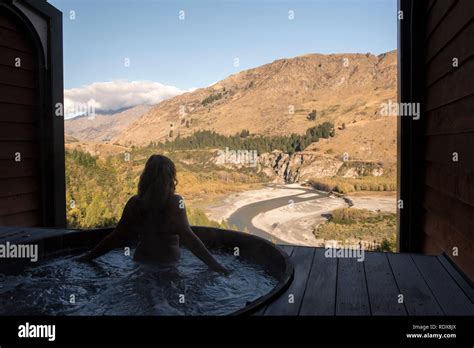 A Woman Model Released Relaxes In A Hot Tub While Enjoying Views Of The Shotover River At The