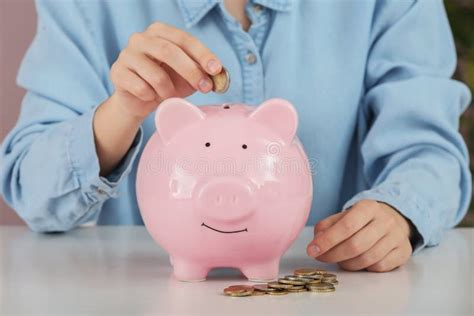 Woman Putting Money Into Piggy Bank Savings Concept Stock Image
