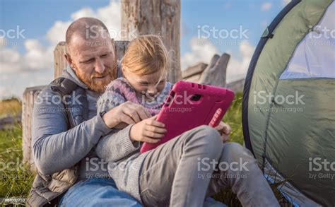 Handsome Redhead Father And Blonde Daughters Using A Tablet Whilst