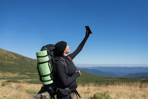 Premium Photo Woman Hiker Stands On The Top Of The Mountain Holds A