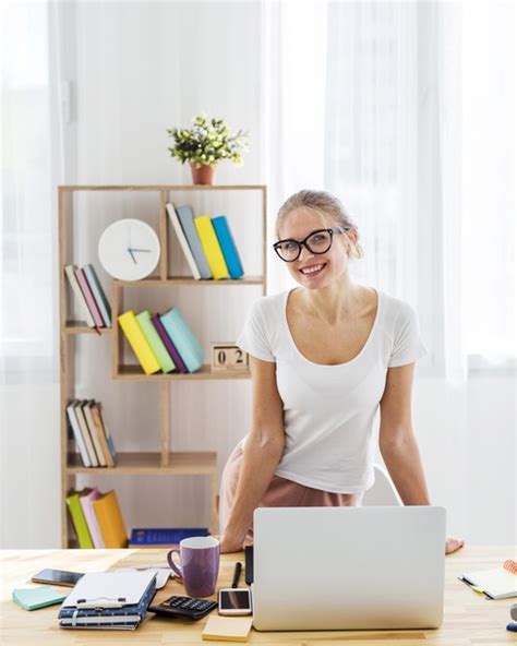 Man ist flexibler, spart sich lange arbeitswege und kann länger von zu hause arbeiten? Vorderansicht der smiley-frau am schreibtisch, die von zu ...