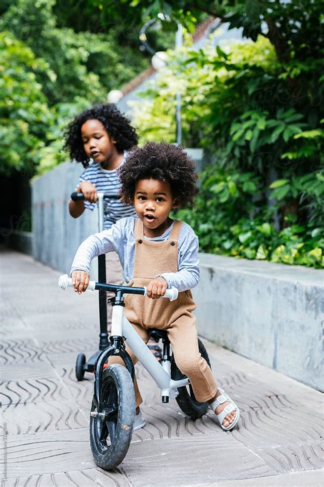 Children Enjoying Riding A Bike And A Scooter By Stocksy Contributor