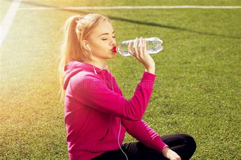 Portrait Of Thirsty Young Beautiful Blonde Hair Fitness Girl Drinking