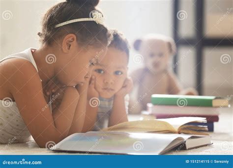 Little African American Children Reading Book At Home Stock Image