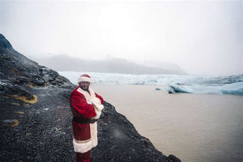 Iceland Smiling Santa Claus Standing In Front Of Glacier Stock Photo