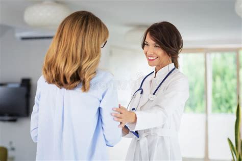 Female Doctor Consulting Her Patient While Standing In Doctor S Office