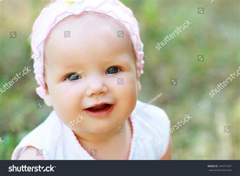 Portrait Of Happy Smiley Baby Girl On Natural Background In Summer