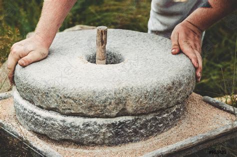 The Ancient Quern Stone Hand Mill With Grain The Man Stock Photo