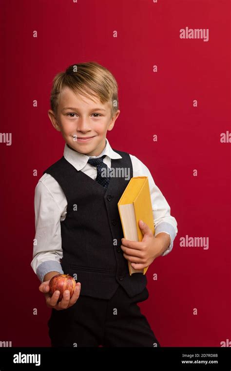 Portrait Handsome Preteen Schoolboy In Uniform In Front Of Red