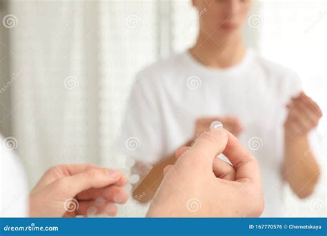 Teen Guy Using Acne Healing Patch Near Mirror Focus On Hands Stock