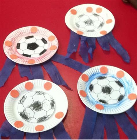 Three Paper Plates With Soccer Balls On Them And Purple Ribbon Around