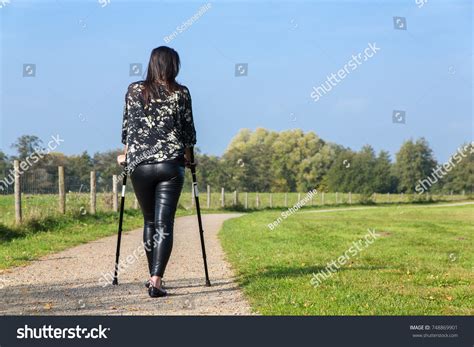 Disabled Young Woman Walking On Crutches Stock Photo 748869901