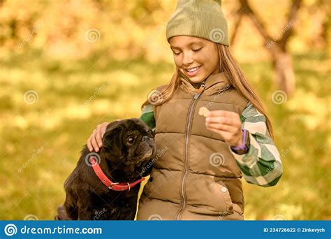 A Girl Feeding Her Dog And Looking Happy Stock Photo Image Of Bulldog