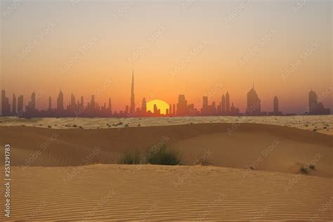 Dubai Skyline Or City Silhouette At Sunset Seen From Arabian Desert