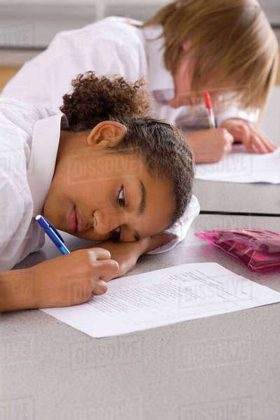 School Girl Taking Test On Desk In Classroom Stock Photo Dissolve