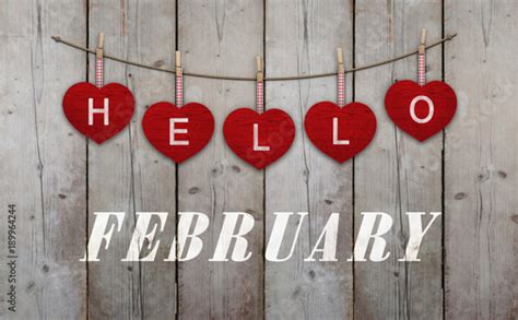 Hello February Written On Hangingred Hearts And Weathered Wooden