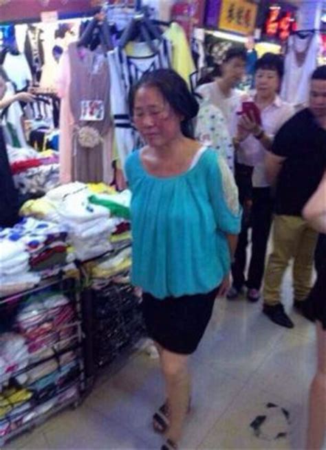 Chinese Shoplifter Made To Sit In Shop Window With Sign Around Her Neck