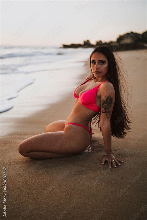 Chica guapa morena en bikini mojada en una playa del sur de españa tomando el sol al atardecer