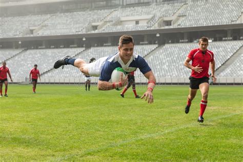 Group Of Diverse Male Rugby Players Playing Rugby In Stadium Stock