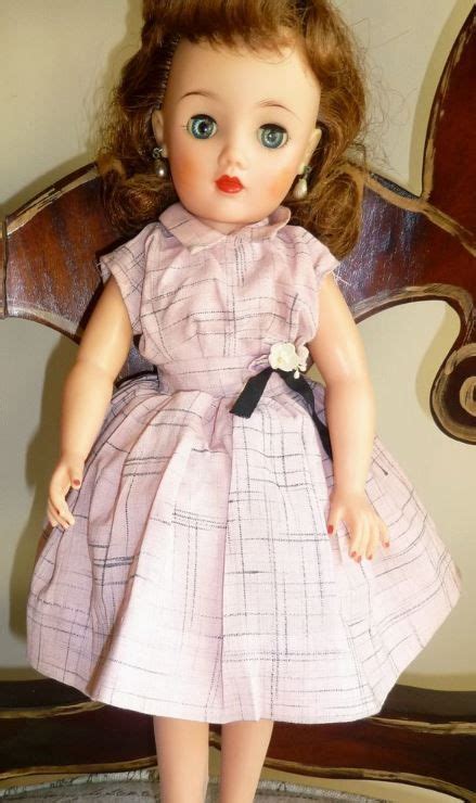 The Doll Is Wearing A Pink Dress And Black Shoes