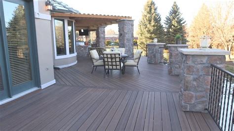 This Sweeping Deck With Stone Column Accents And Pergola Has Plenty Of