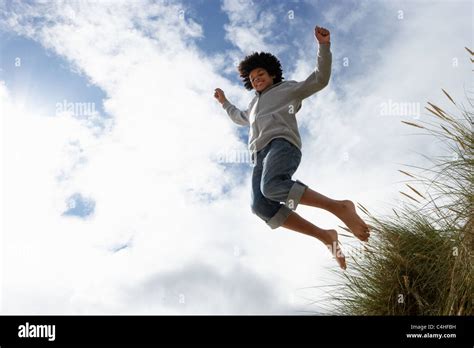 Boy Jumping Over Dune Stock Photo Alamy